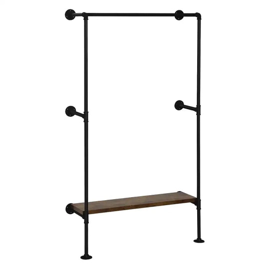 Een industriële kledingrek met donkergrijs metaal en houten hangers, beladen met jassen en een kledingstuk met ruitpatroon. Onderaan rust een houten plank met een handtas, plant en schoenen, ideaal voor een moderne kledingopslag in een woonkamer of slaapkamer.