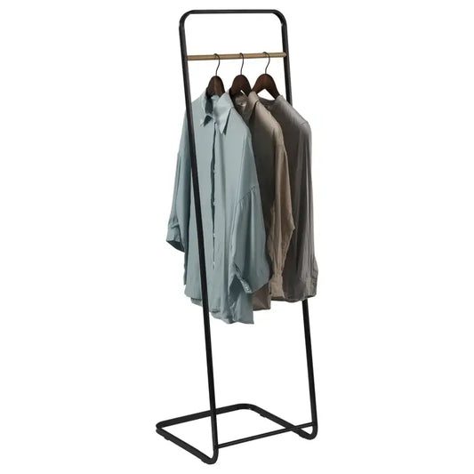Een minimalistisch zwart metalen kledingrek met houten balk, beladen met lichtblauwe en beige overhemden op houten hangers, ideaal voor moderne woonruimtes of kledingverzorging.