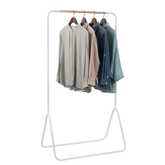 Een witte kledingrek met houten hangers, waarop vier linnen shirts in beige, blauw en groen hangen. Ideaal voor kledingopslag in woonruimte of kantoor.