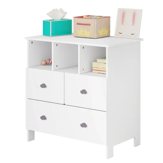 Wit houten kinderkast met drie laden en open vakken, voorzien van grijze wolkjeskrukjes. Geschikt voor babykamer of kinderkamer met speelgoed en boeken opgestapeld.