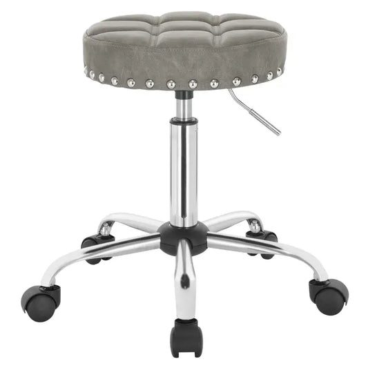 Een witte, gepolsterde kruk met zilveren naaiwerk en een glanzende metalen potenstructuur, uitgerust met zwarte wielen voor mobiele gebruik in een salon of kantoor.