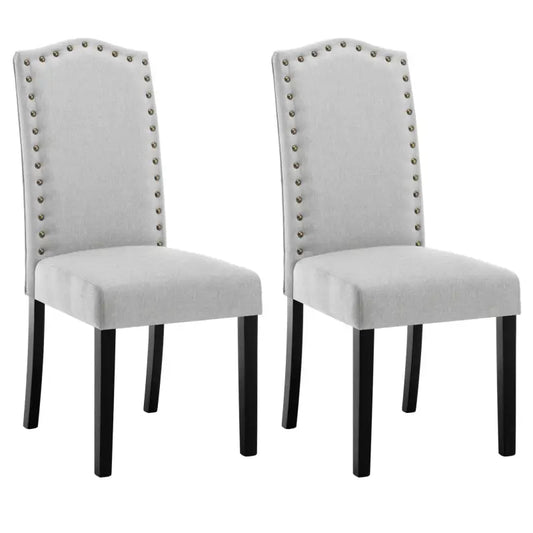 Grijze, fluweelbeklede eetkamerstoelen met elegante metalen knoppen langs de rugleuning en zwarte houten poten, perfect voor een moderne of klassieke eetkamer.