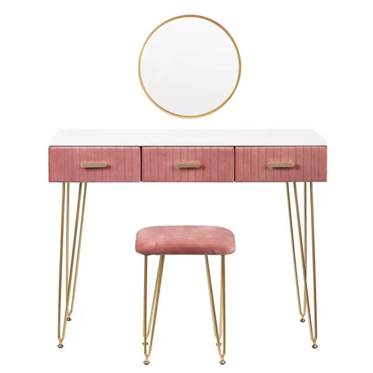 Een roze velours make-up tafel met drie laden en goudkleurige haakbenen, voorzien van een ronde spiegel. Perfect voor een moderne slaapkamer of make-up hoek.