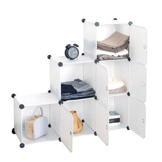 Wit opbergkast met transparante deuren, gevuld met kleding, een klok, een handtas en een vaas. Ideaal voor kleine ruimtes en flexibel opbergen in slaapkamers of woonkamers.