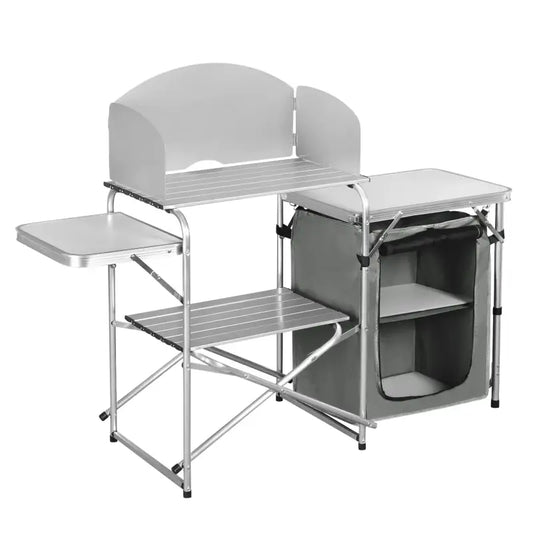 Zilverkleurige vouwbare kampeerkeuken met aluminium frame, witte werkbladen en opbergvakken. Ideaal voor kampen, picknicks of buitenkeukens waar ruimte en functionaliteit belangrijk zijn.