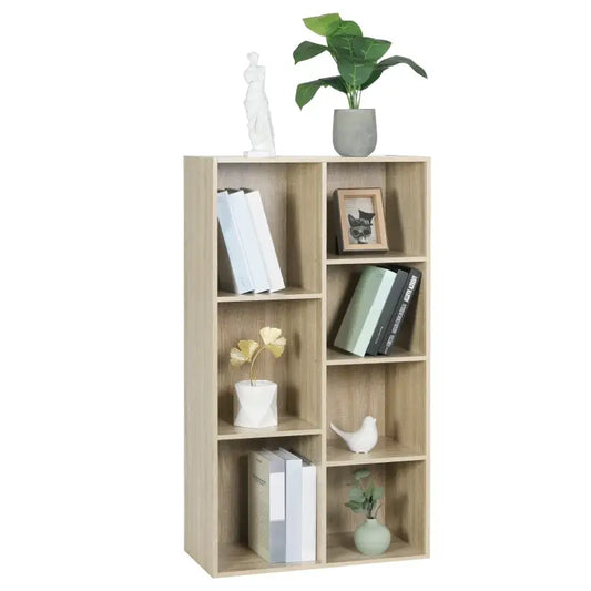 Een licht houten boekenkast met open vakken, gevuld met boeken, een fotolijst, decoratieve planten en een witte beeldhouwwerk. Ideaal voor woonkamer of slaapkamer als opberg- en decoratief element.