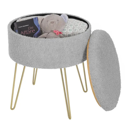 Grijze, fluweelachtige kussenschoen met goudkleurige hoge poten, ideaal als decoratieve zitplaats in een moderne woonkamer of als opbergstoel voor kleine ruimtes.