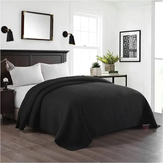 Grijze, gestikt dekbed met ruitpatroon op een modern bed in een minimalistische slaapkamer. Perfect voor comfort en stijl in een moderne slaapkamer.