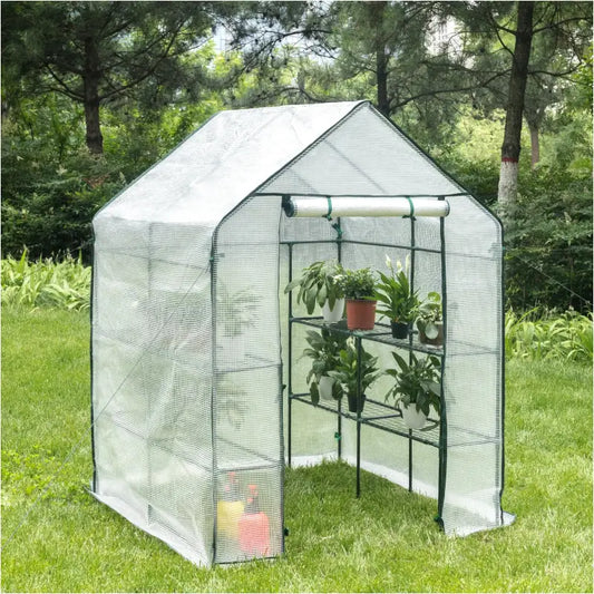 Een witte, mesh-geweven tuinserre met groene metalen frame staat op een groen gazon. Binnen staan potten met groene planten, geschikt voor tuinbouw en bloemenkweken.