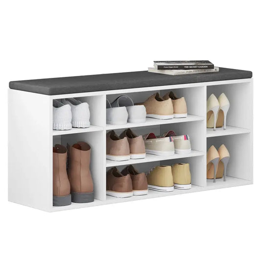 Een witte, modulare opbergkast met een donkergrijze zitbank, geschikt voor woonkamer of slaapkamer. De kast heeft meerdere vakken voor opslag en biedt comfort bij gebruik als bank.