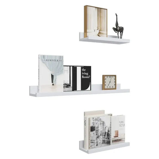 Wit wandplankset met drie niveaus, voorzien van boeken, een klok en decoratieve objecten. Ideaal voor minimalistische woonruimtes of kantoordecoratie.