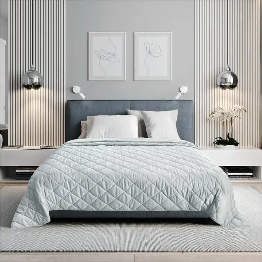 Lichtgrijze, gestikte deken met diagonale patroon op een modern bed in een minimalistische slaapkamer. Perfect voor comfort en stijl in een moderne slaapkamer.