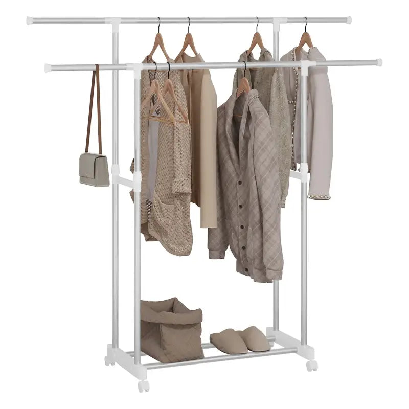 Een witte, dubbele kledingrek met wielen, beladen met beige kledingstukken op houten hangers, een handtas en slippers, geschikt voor kameropslag of kledingverzorging.