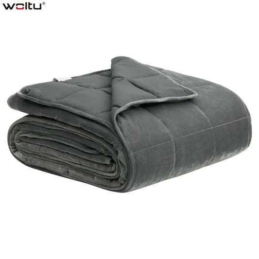 Grijze, gestikte deken van zachte microfiber, opgevouwen met zichtbare naadwerk en een lichte rand. Ideaal voor comfortabele slaap en ontspanning in de woonkamer of slaapkamer.