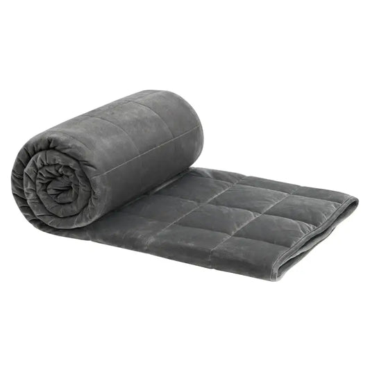 Grijs, gestikt dekbed van zachte microfiber, opgevouwen met zichtbare naadwerk en een klein wit etiket. Ideaal voor comfortabele slaap en ontspanning in de woonkamer of slaapkamer.