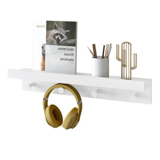 Een witte wandplank met haken, waarop een gouden koptelefoon hangt, een boek over Amerikaanse dieren, een potloodhouder en een gouden kaktusdecoratie zijn geplaatst. Ideaal voor een moderne kantoor- of woonruimte.