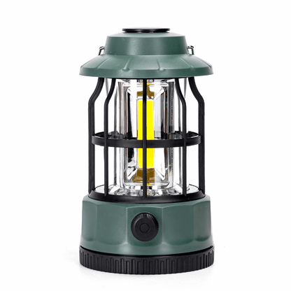 Groene, waterdichte zaklamp met zichtbare LED-verlichting en zwarte metalen kooi, geschikt voor avonturen en nachttochten. Inzoom op batterijcompartiment en gebruik in een kelder.