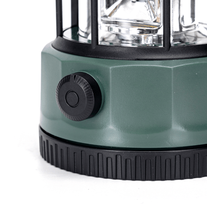 Groene, waterdichte zaklamp met zichtbare LED-verlichting en zwarte metalen kooi, geschikt voor avonturen en nachttochten. Inzoom: batterijcompartiment en gebruik in een kelder.
