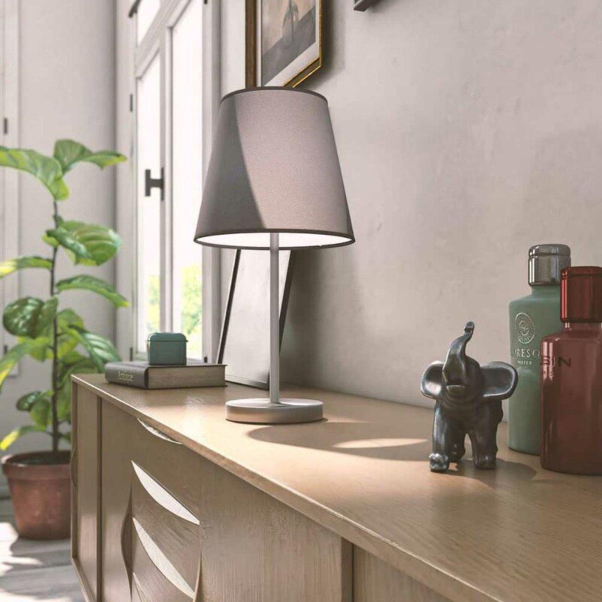 Een moderne tafellamp met een grijze stoffen kap en een zilverkleurige metalen standaard, ideaal voor een minimalistisch interieur. Perfect voor slaapkamer of woonkamer verlichting.
