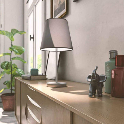 Een moderne tafellamp met een grijze stoffen kap en een zilverkleurige metalen standaard, ideaal voor een minimalistisch interieur. Perfect voor slaapkamer of woonkamer verlichting.
