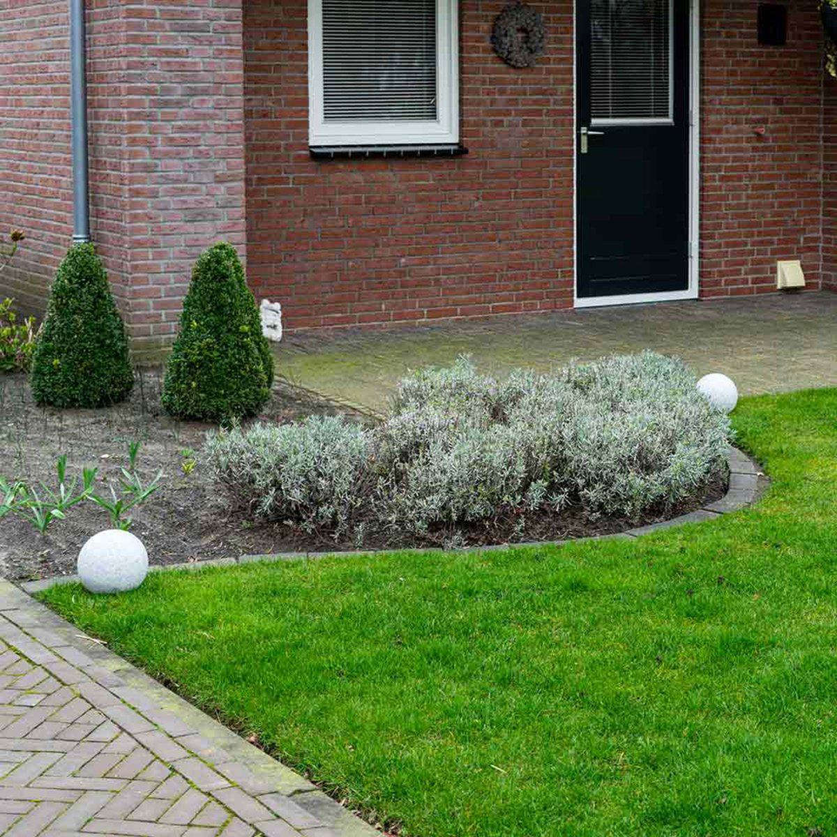 Grote, grijze, granieten tuinbal met zwarte spitsen voor aardigheid. Perfect voor buitenverlichting en tuinversiering, zowel in de tuin als op terras.