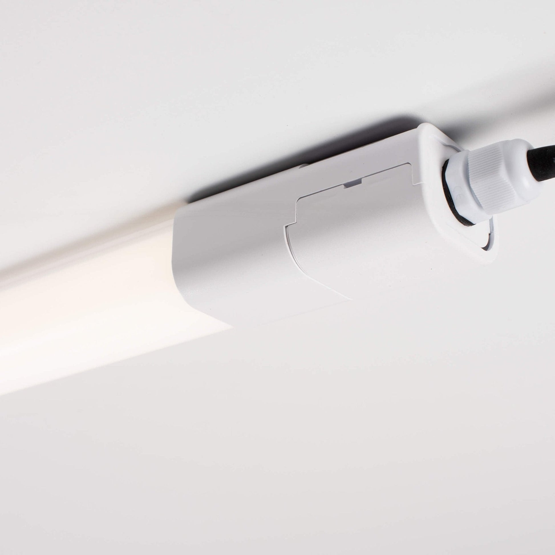 Een witte, langwerpige LED-lamp met IP65 beschermdheid en een zichtbare verpakking. Geschikt voor gebruik in keukens, badkamers of industriële ruimtes waar waterbestendigheid essentieel is.