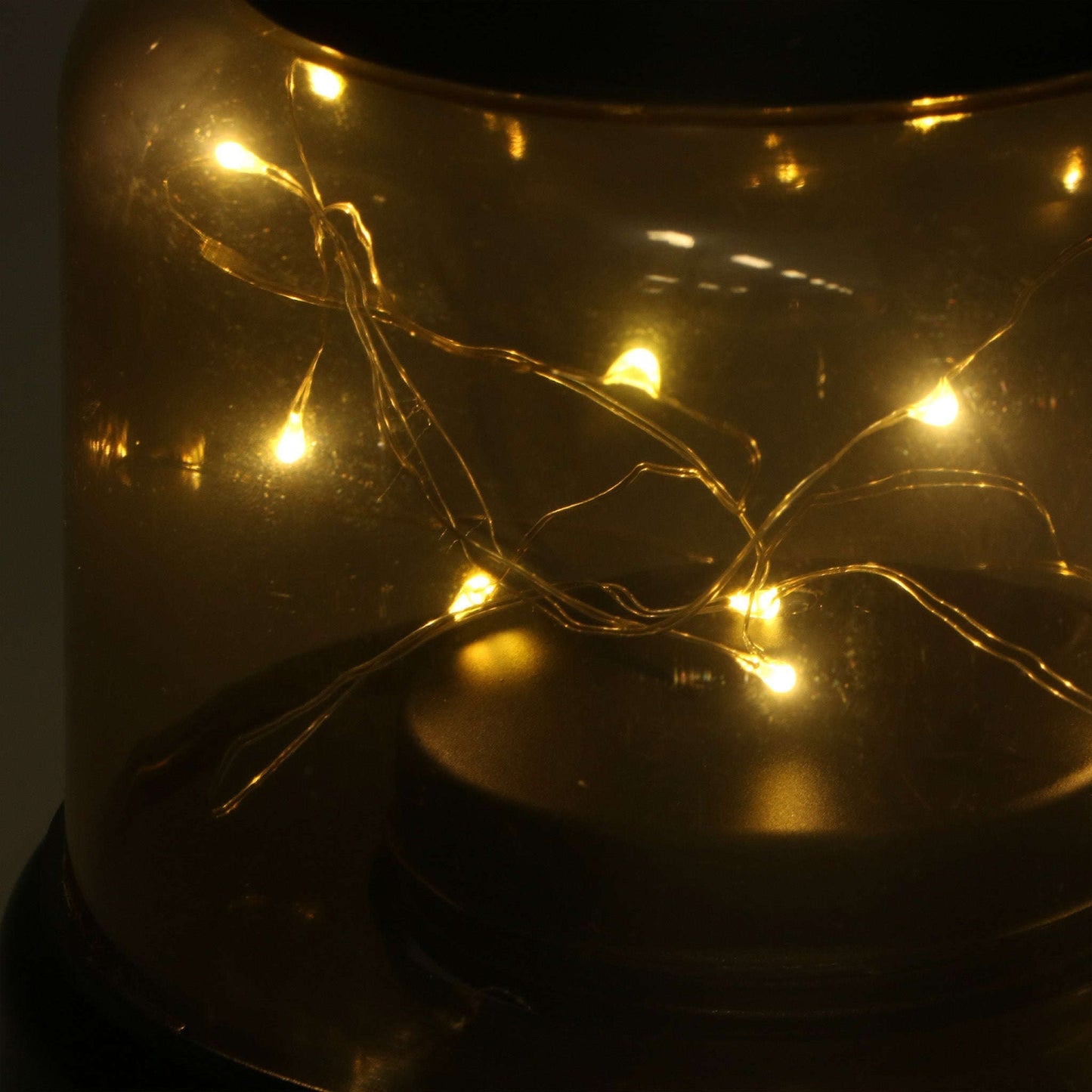 Een zwart metalen hanglamp met een transparante glazen kap, waarin warme LED-lampjes zijn geïntegreerd. Perfect voor sfeerverlichting in de woonkamer of bij avondmaaltijden.