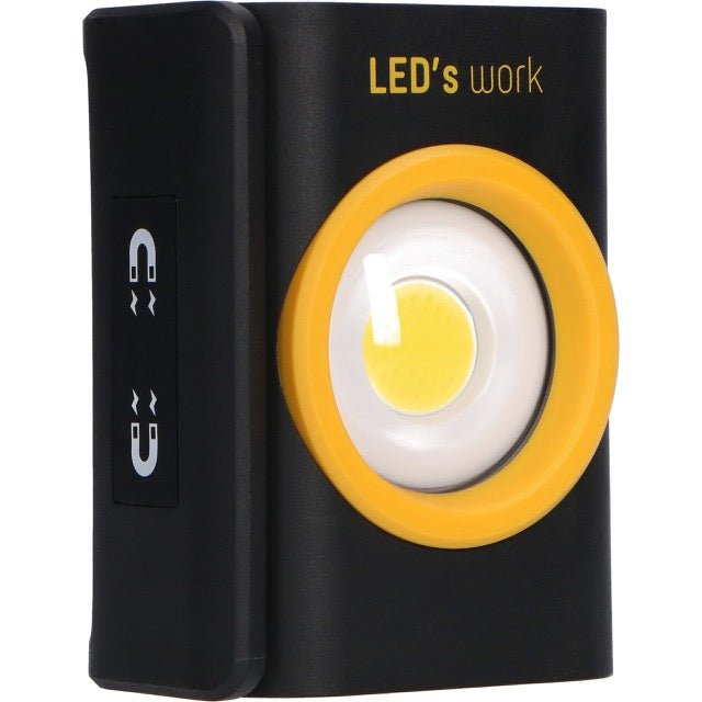 Zwart LED-lampje met geel kader en magnetische aansluiting, voor gebruik in werkomgevingen. Geen batterij nodig, geschikt voor reparaties en onderhoud.
