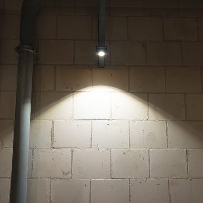 Zwart LED-lampje met geel kader en magnetische aansluiting, voorzien van een witte reflector en het opschrift 'LED's work'. Ideaal voor werkplekverlichting en mobiele gebruik.