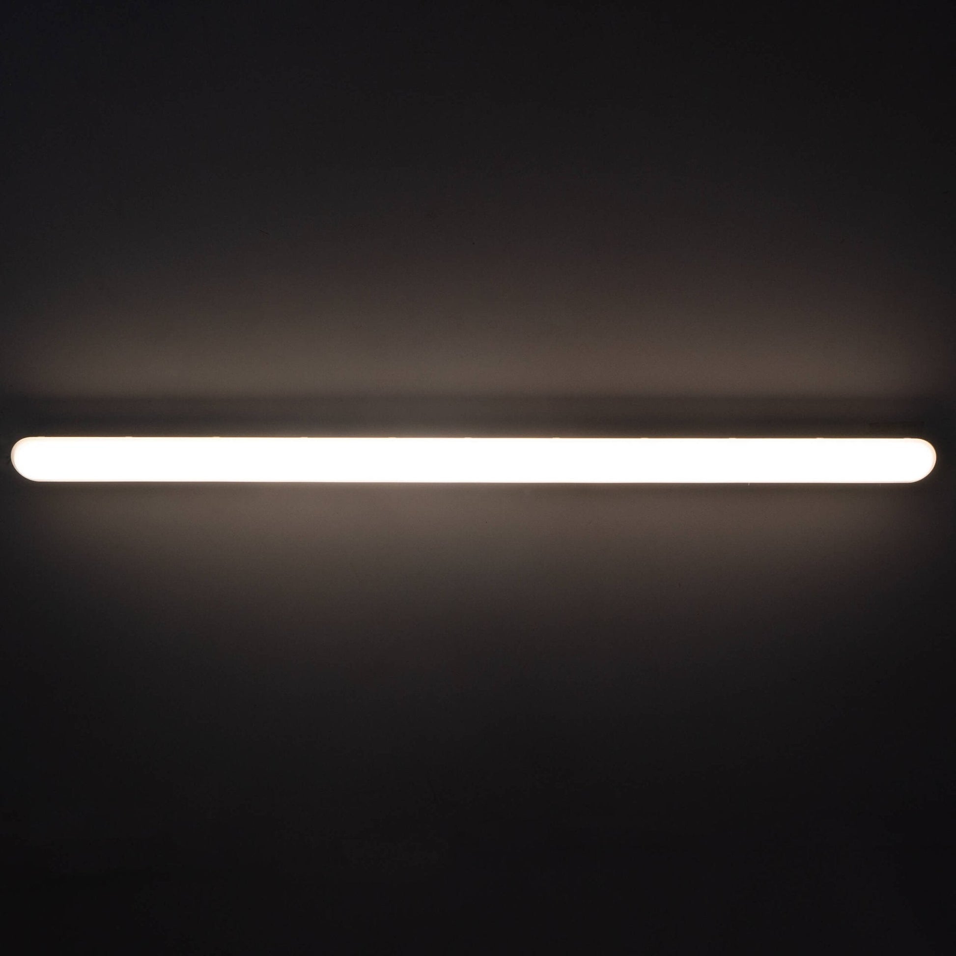 Een witte, langwerpige LED-lamp met vier zichtbare lichtbronnen en een glanzend, transparant plastic kap. Geschikt voor industriële verlichting en ruimtes met hoge plafonds.