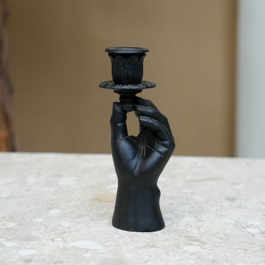 Zwart handvormig kaarsenhouder met gedetailleerde vingers en klassieke kaarsenkap, gemaakt van glanzend materiaal. Perfect voor gotische of vintage interieurs als decoratief accessoire.