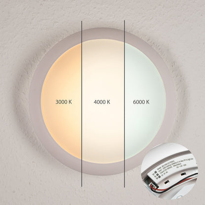 Een witte, ronde LED-plafondlamp met drie kleurtemperaturen: 3000K, 4000K en 6000K, zichtbaar op een textuurrijke muur. Inclusief detail van de elektrische aansluiting voor gemakkelijke installatie.