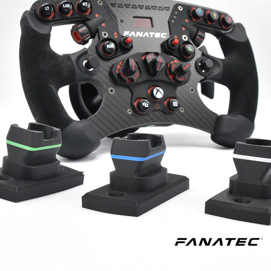 Een zwarte Fanatec racestuur met rode knoppen en carbonlook, geplaatst naast drie zwarte pedaalstukken met kleuraccenten. Geschikt voor racegames en professionele simulaties op Xbox.