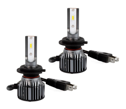 Zilverkleurige LED-autohalogeenlampen met zwarte koelringen en gele chip, voorzien van stekkerkabels. Geschikt voor verlichting van auto’s en motorfietsen.