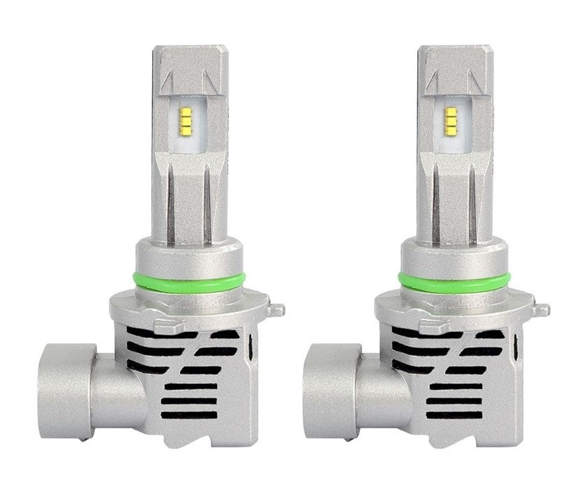 Zilverkleurige LED-autohalogeenlampen met groene isolatieband en koelingsgaten, geschikt voor nachtverkeer en rijden in slecht zicht. Zichtbare gele LED-chips en metalen behuizing met ventilatieopeningen.