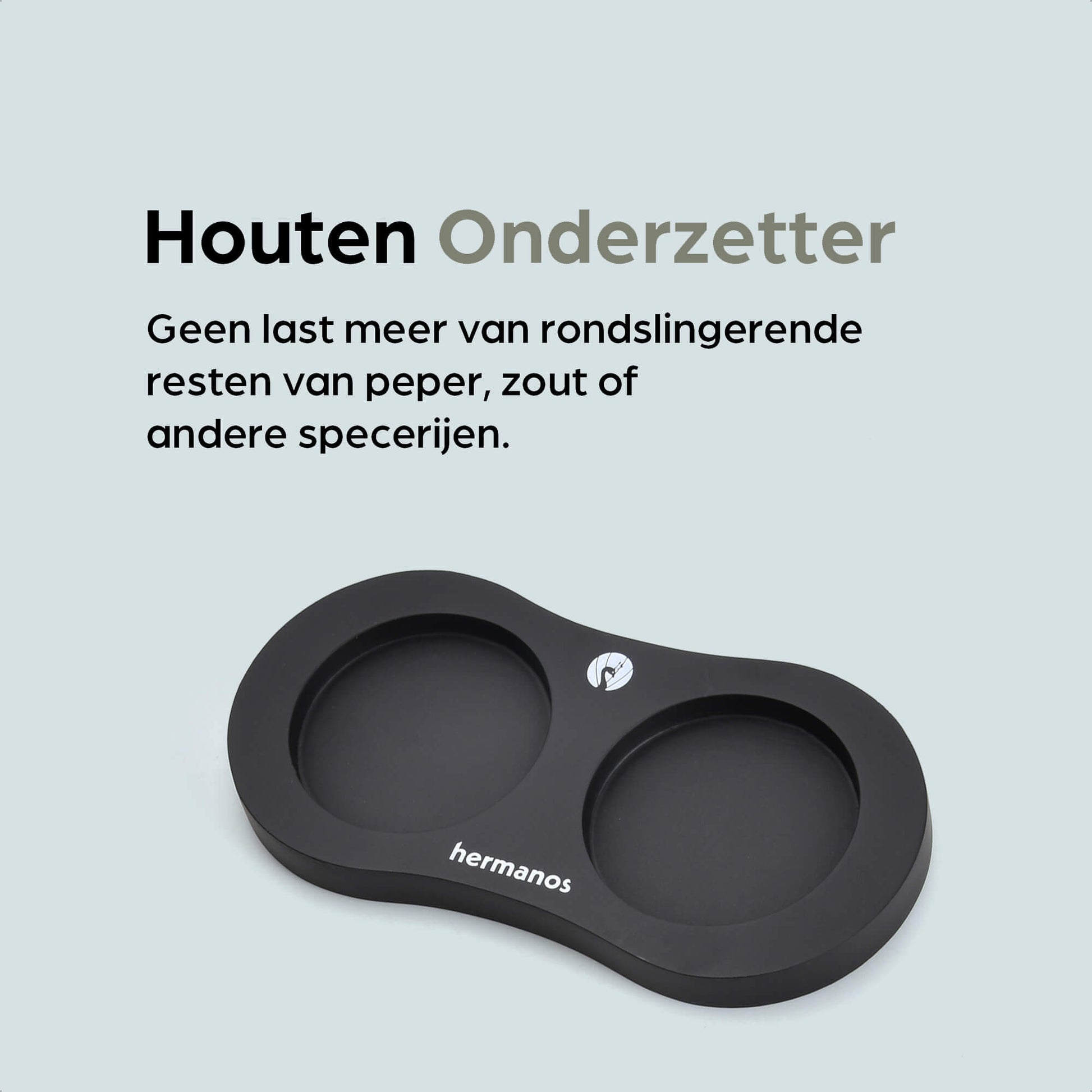 Een witte en zwarte houten pepermolen met goudkleurige doppen, geplaatst op een zwarte standaard met het merk 'hermanos'. Inclusief extra zilveren doppen voor keuken- en eetkamergebruik.