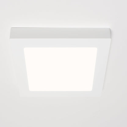 Een witte, vierkante LED-downlight met zichtbare afwerking, geplaatst naast zijn verpakking. Geschikt voor zowel ingebouwde als oppervlakkige installatie in moderne interieurs.
