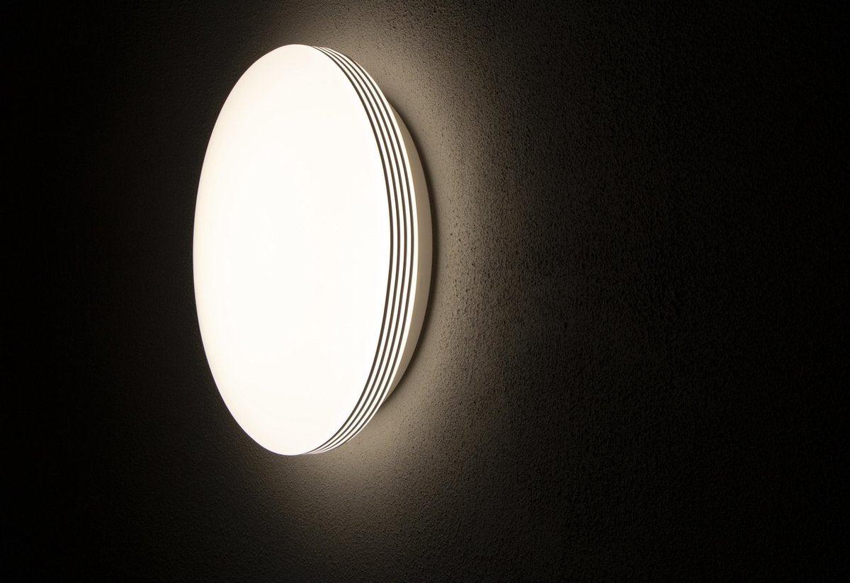 Een witte, ronde plafondlamp met glanzende chromen randen en een mat witte diffuser. Geschikt voor moderne interieurs en als energiezuinige verlichting in woon- en werkkamers.