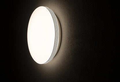 Een witte, ronde plafondlamp met glanzende chromen randen en een mat witte diffuser. Geschikt voor moderne interieurs en als energiezuinige verlichting in woon- en werkkamers.