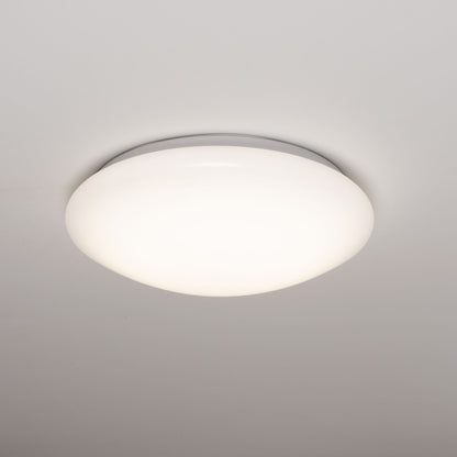 Een witte, ronde plafondlamp met een gladde, mat-witte diffuser en een zilverkleurige rand. Geschikt voor moderne interieurs en als energiezuinige verlichting in woon- en werkkamers.
