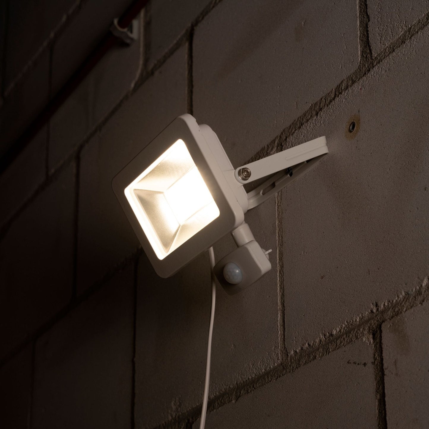 Wit LED-stralingslamp met bewegingssensor, voor buitenverlichting. Zichtbare LED’s en zilverkleurige reflector, geschikt voor tuin- en terrasverlichting.