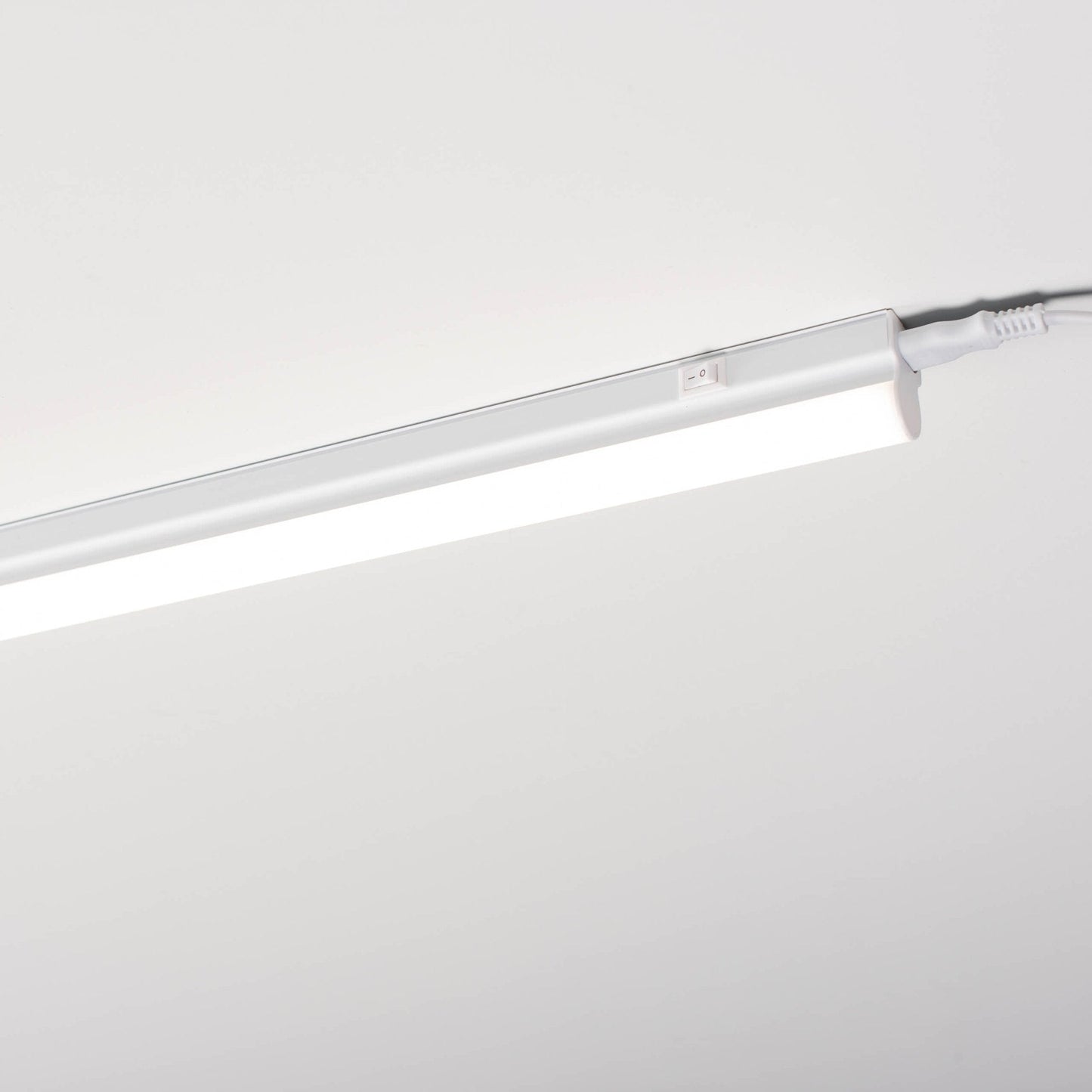 Een witte LED-bakverlichting met schakelaar, kabel en Europese stekker, compleet met montagebeugels en schroeven voor onderbouwverlichting in keuken of kasten.