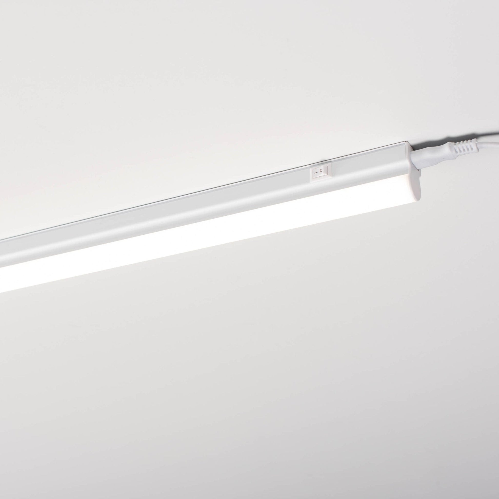 Een witte LED-bakverlichting met schakelaar, kabel en Europese stekker, compleet met montagebeugels en schroeven voor onderbouwverlichting in keuken of kasten.