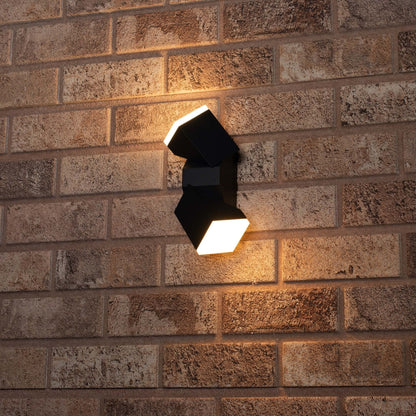Zwart, modern buitenverlichting met twee heldere LED-panelen, gemonteerd op een roodbruine stenen muur. Verlichting voor tuin of terras, ideaal voor avondelijke sfeer en veiligheid.