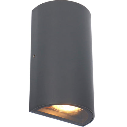 Zwart, cilindrisch wandlampje met warm wit licht, bevestigd aan een textuurrijke bakstenen muur. Ideaal voor buitenverlichting en moderne tuin- of terrasdecoratie.
