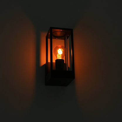 Een zwart, rechthoekig wandlampje met glazen panelen en een gloeiende filamentlamp, perfect voor buitenverlichting. De warme gloed creëert een sfeervolle, moderne verlichting voor terrassen of entrees.