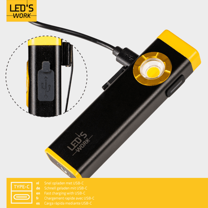 Een zwarte en gele LED-stoklamp met USB-oplaadfunctie, geschikt voor wandelingen en avonturen. Zichtbaar in gebruik in de nacht en in de zak, met een heldere lichtbron voor veiligheid.