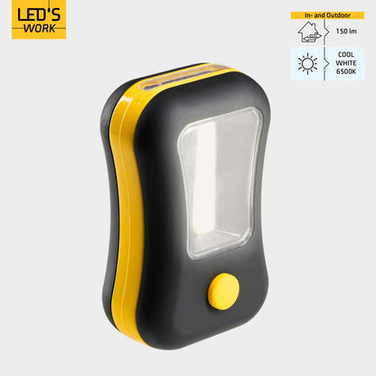 Compacte, zwarte en gele zaklamp met een heldere LED-lichtbron en een opvallende gele knop. Geschikt voor gebruik in het donker, bijvoorbeeld tijdens kamperen of reparaties.