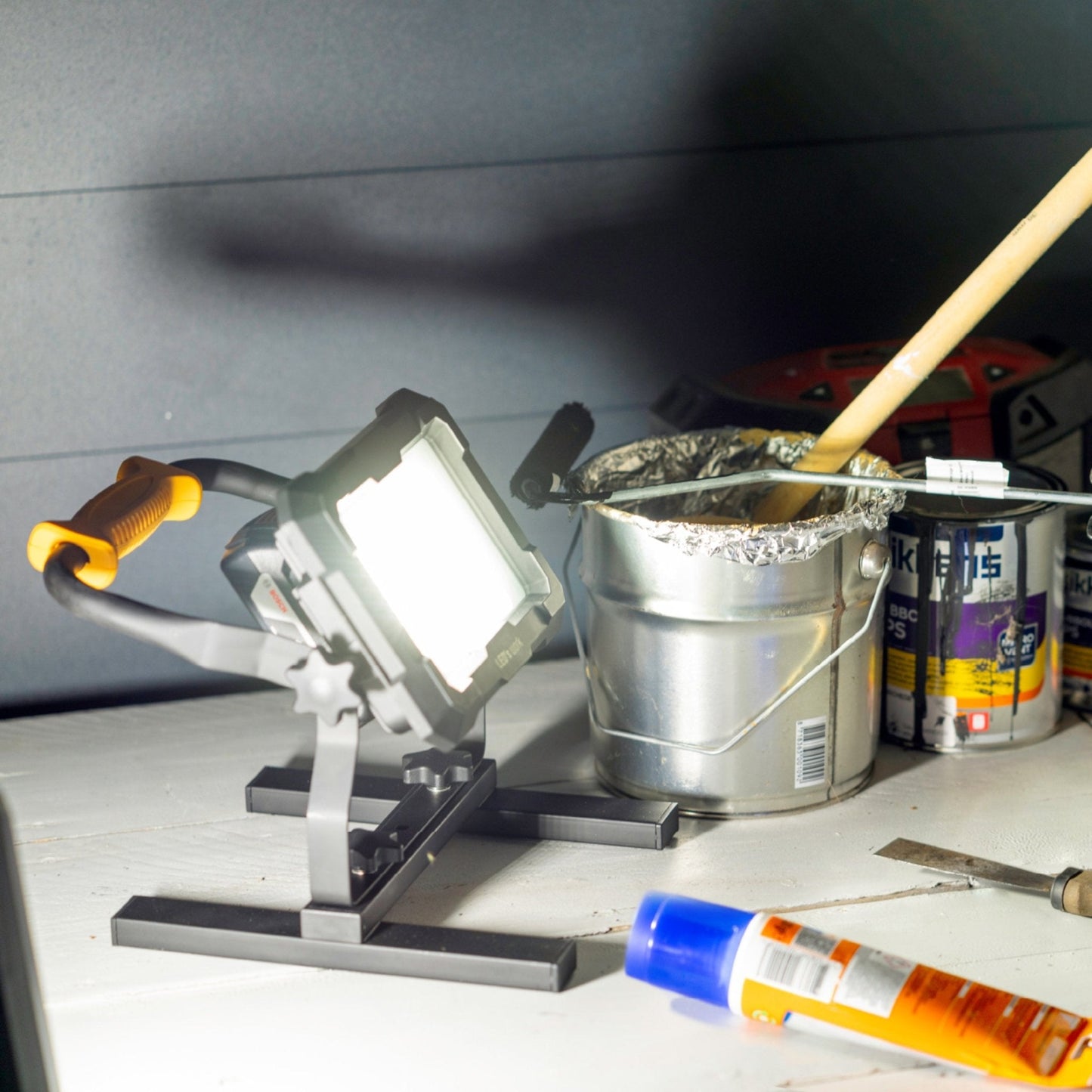 LED’s work werklicht met gele handgreep en zwarte kast, voorzien van vier adapters voor Bosch, Einhell, Makita en Metabo. Ideaal voor professionele werkomgevingen en reparaties.