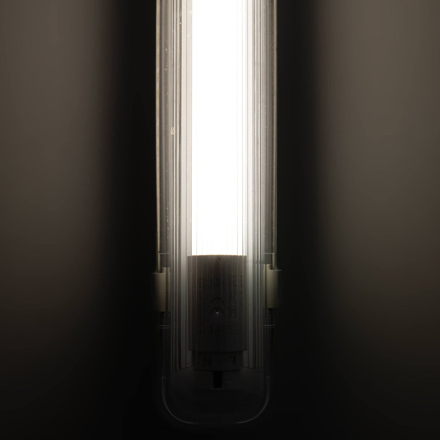 Een witte, 120 cm lange LED-verlichting met een glazen kap en een zichtbare G13-connector, geschikt voor professionele verlichting in winkels of kantoren.